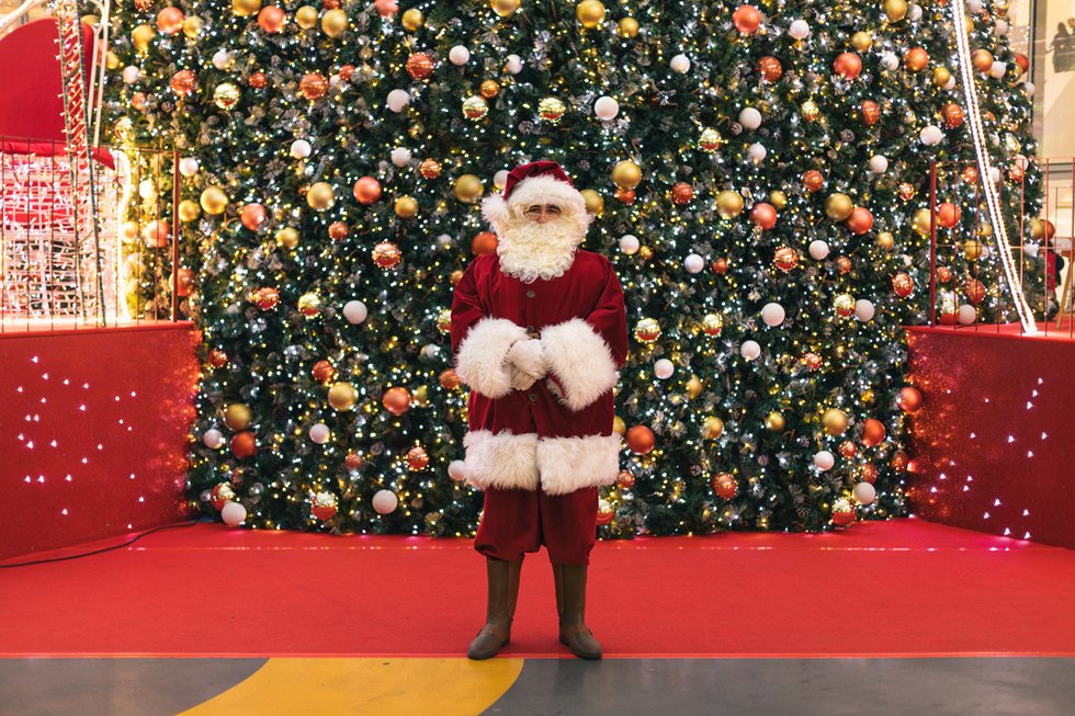 Le père Noël met des cadeaux sous le sapin